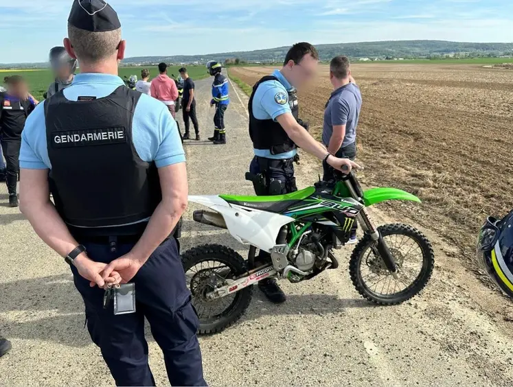 Gendarmes interpellant des jeunes pratiquant un rodéo sauvage à moto cross dans un champ