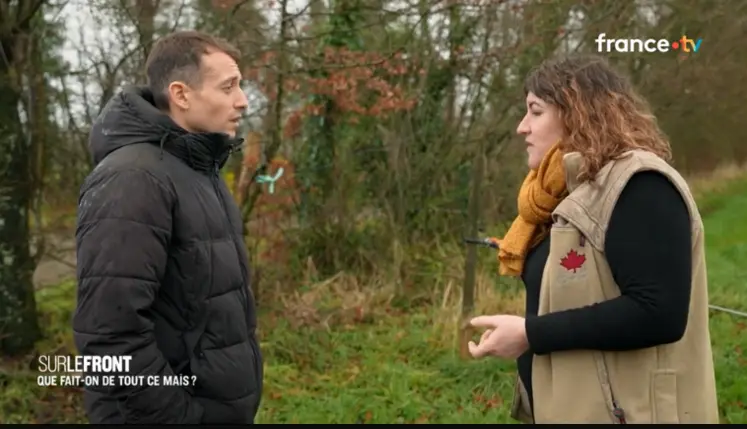 Hugo Clément discuant avec une éleveuse dans une prairie devant une haie.