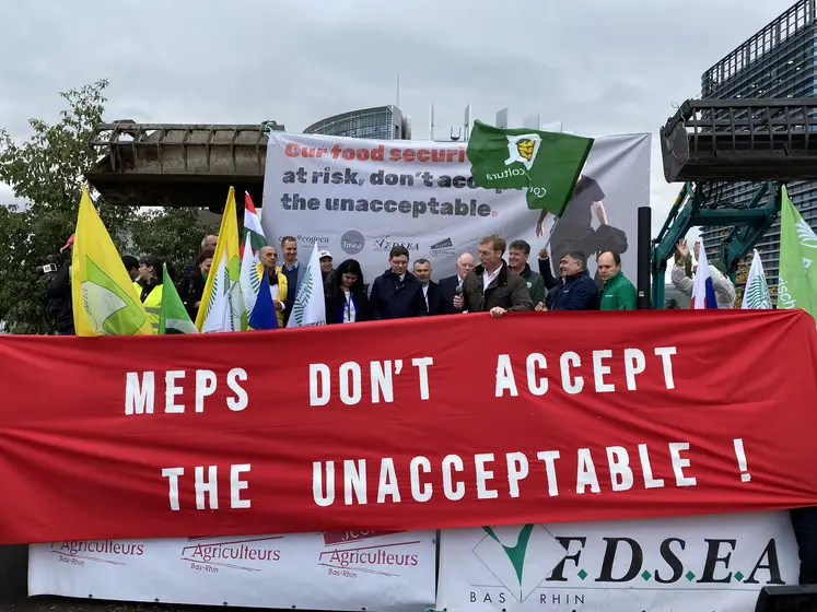 Devant le Parlement européen le 21 octobre, les représentants du Copa-Cogeca et de la FNSEA appellent les eurodéputés à refuser les propositions de la Commission européenne. Des drapeaux sont mis en avant, ainsi qu'une affiche rouge avec un slogan en anglais qui signifie « Eurodéputés, n’acceptez pas l’inacceptable ».
