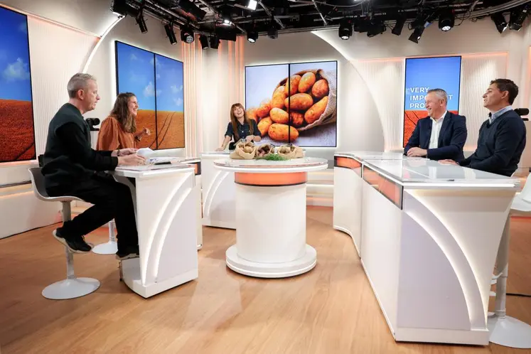 Plateau de télévision avec cinq personnes assises derrière un pupitre