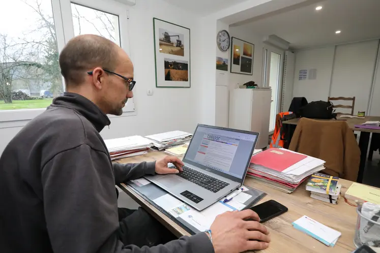 Un homme assis devant un ordinateur portable sur un bureau