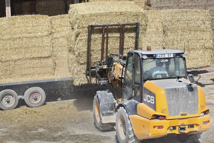 tracteur chargeant des bottes de paille