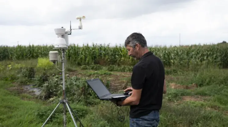 homme tenant un ordinateur dans un champ
