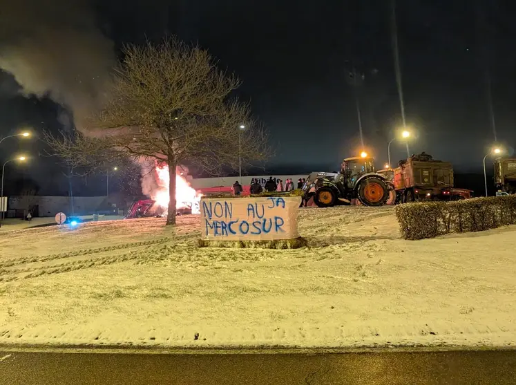 Tracteurs sur un rond point, avec un feu, et une banderole "non au Mercosur"
