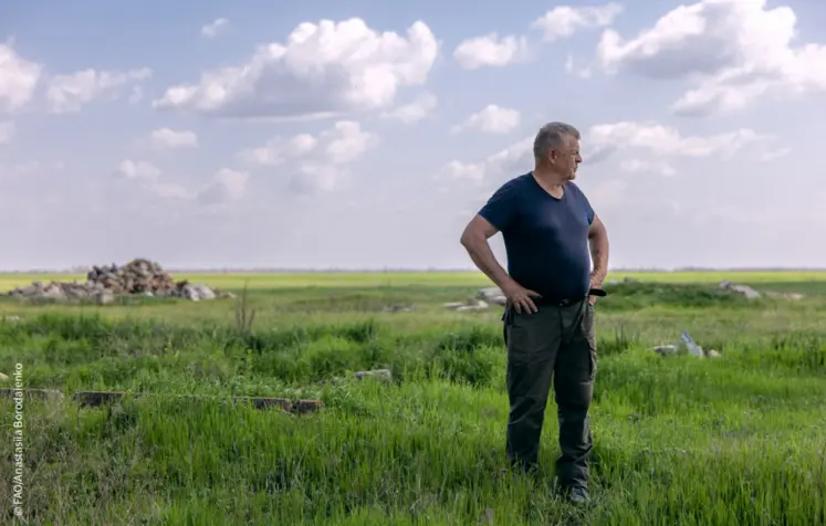 agriculteur dans son champ avec débris au sol