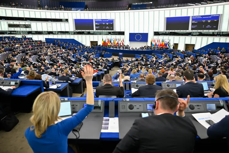 Députés européens vus de dos et levant la main pour voter lors d'une session du Parlement européen