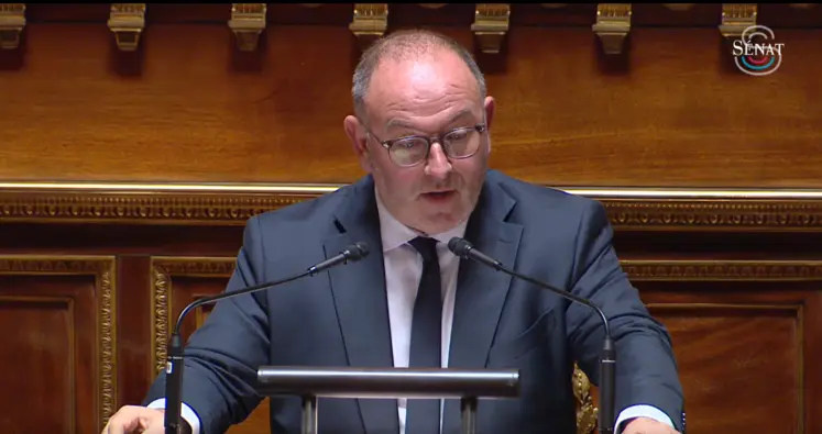 un homme au micro dans l'enceinte du Sénat