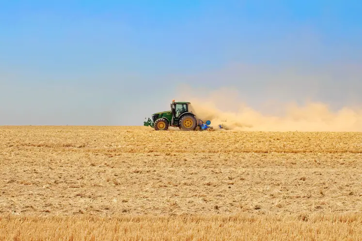 Tracteur dans un champ très sec après la moisson