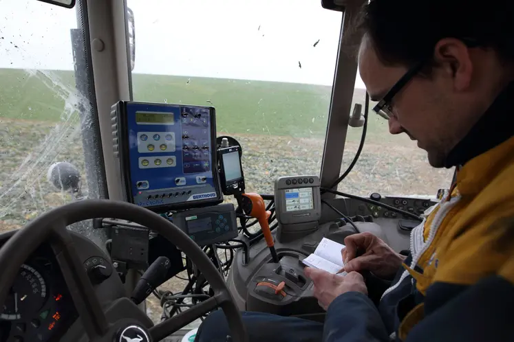 Agriculteur dans son tracteur notant dans son carnet les traitements phyto réalisés.