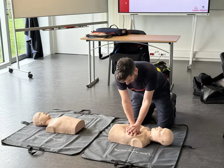 Massage cardiaque réalisé sur un mannequin par un pompier lors d'une formation aux premiers secours