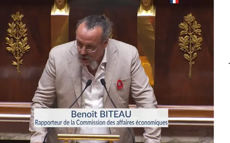 un homme à la tribune de l'assemblée nationale s'exprimant devant un micro
