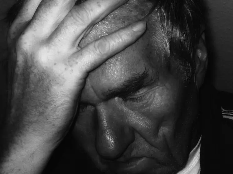 homme se tenant la tête dans la main