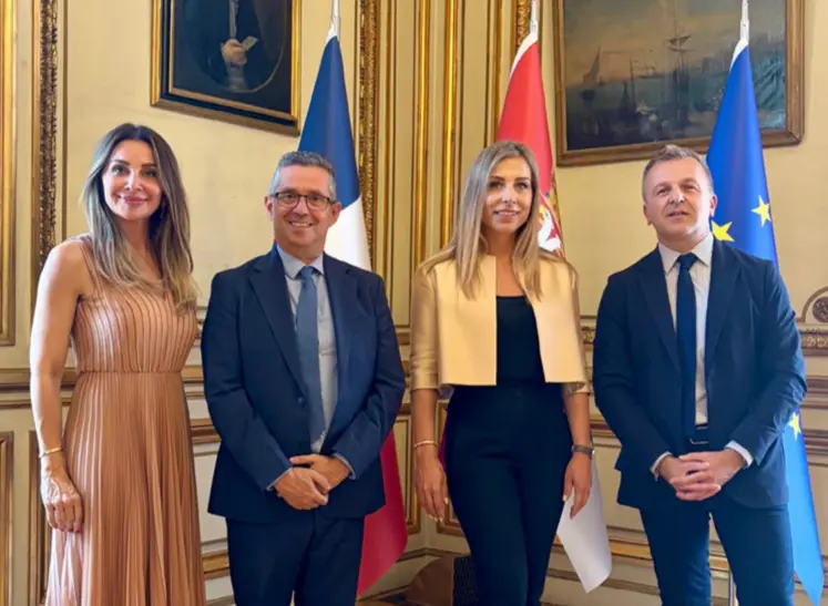 Deux hommes et deux femmes posent pour la photo avec des derapeaux en arrière-plan