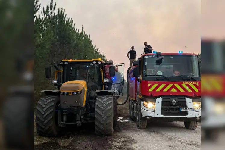 Tracteur ravitaillant un camion de pompier en eau lors de l'incendie en Gironde.