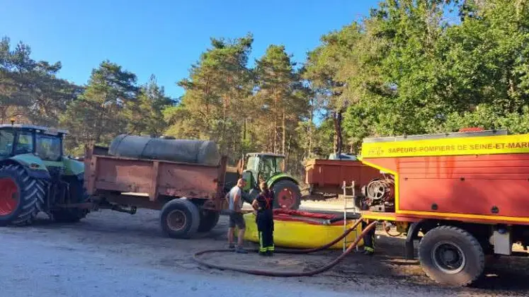Agriculteur aidant à ravitailler les pompiers en eau dans la forêt de Fontainebleau avec sa tonne à eau.