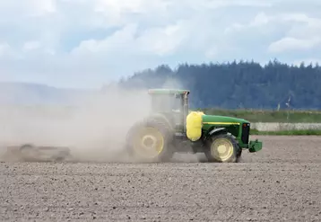 Tracteur dans un champ frappé par la sécheresse