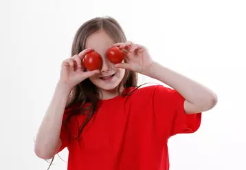 enfant avec deux tomates 