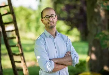   Benoît Grimonprez, professeur à l’université de Poitiers, dans un verger devant une échelle.