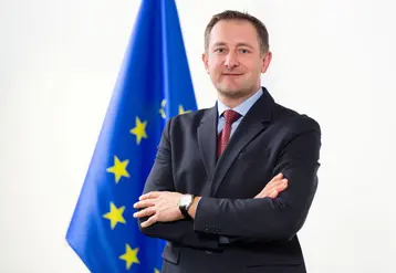 Christophe Hansen, Commissaire européen désigné pour l'Agriculture, devant un drapeau européen