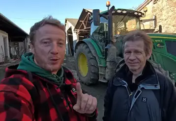 Etienne Fourmont et Jean-Marc Jancovici devant un tracteur dans une cour de ferme.