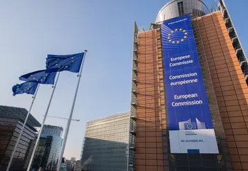 Bâitment du siège de la Commission européenne à Bruxelles, avec des drapeaux européens. 