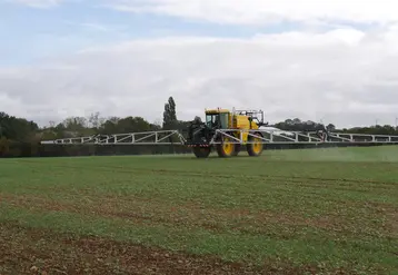 tracteur épandant des pesticides dans un champ