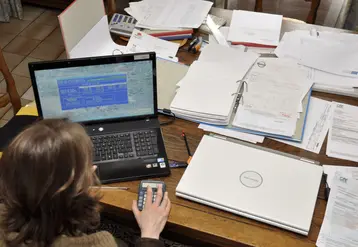 Agricultrice devant un ordinateur avec une calculatrice