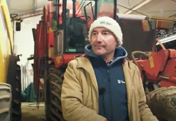 Bruno Cardot dans un hangar devant des tracteurs