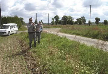 deux agents de l'OFB en bordure de champ à côté d'une route