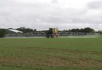tracteur pulvérisant des pesticides dans un champ