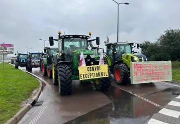 Convoi de tracteur avec un slogan placardé devant "Mercosur c'est de la malbouffe à coup sûr"