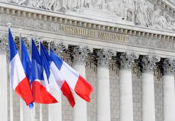 drapeaux français flottant devant la façade de l'Assemblée nationale