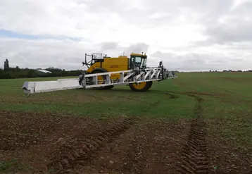 tracteur épandant des pesticides dans un champ