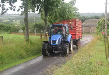 tracteur avec une remorque circulant sur un chemin de campagne 