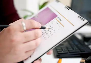 Une personne entoure la date d'un calendrier