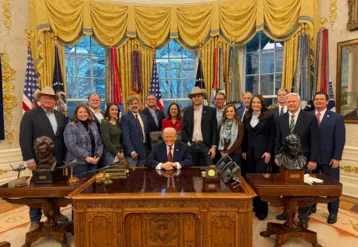 donald trump entouré de plusieurs personnes dans le bureau ovale