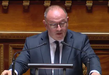 un homme au micro dans l'enceinte du Sénat