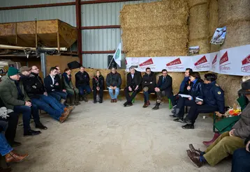 La ministre de l'Agriculture Annie Genevard assise devant de la paille sur une exploitation ovine en Haute-Marne, avec des représentants syndicaux des Jeunes agriculteurs et de la FNSEA.