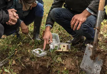 Diagnostic d'un sol agricole par trois personnes avec leurs outils dans le cadre du calcul d'un indice de régénération. 