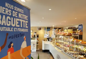 intérieur d'une boulangerie avec à l'entrée un panneau agri-éthique