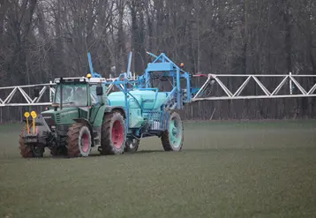 tracteur épandant de l'engrais dans un champ