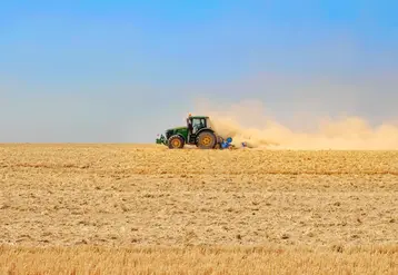 Tracteur dans un champ très sec après la moisson