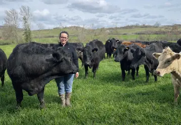 L'éleveuse Mathilde Deramond dans une prairie de son exploitation en Ariège avec ses bovins allaitants, des Limousins et des Angus