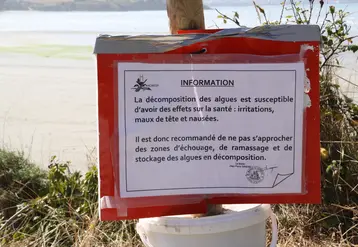 panneau en bord de mer prévenant d'une pollution de l'eau aux algues vertes