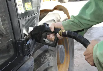 agriculteur tenant un pistolet pour faire le plein de son tracteur