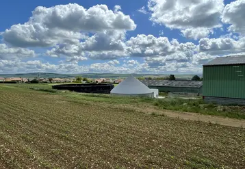 Microméthaniseur à côté d'un bâtiment d'élevage.