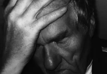 homme se tenant la tête dans la main