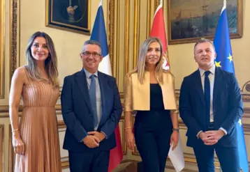 Deux hommes et deux femmes posent pour la photo avec des derapeaux en arrière-plan