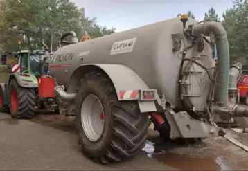 citerne agrciole arrêtée sur une route avec un cmaion de pompiers à côté