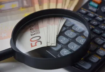 billets de 50 euros avec une loupe et une calculatrice